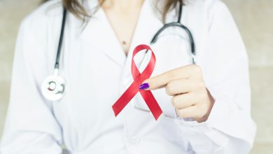 ilustrasi dokter membawa pita merah simbol dukungan kepada penderita HIV/AIDS. (unsplash.com/Bermix Studio)